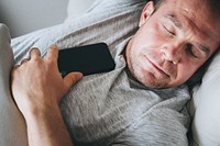 Man asleep on the sofa with his phone on his chest