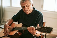 Senior man playing on his guitar