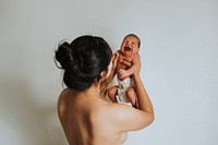 Naked mother holding her infant baby