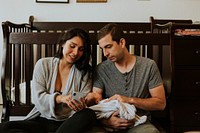 Family holding a baby and playing on the phone