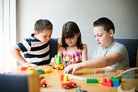 Siblings playing with blocks, trains and cars