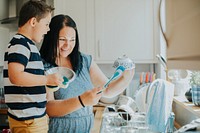 Mother teaching son how to do the dishes