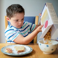 Boy pouring cornflakes into a bowl
