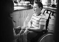 Sister helping her disabled brother in the kitchen