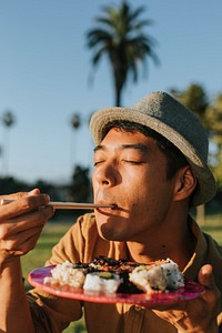 Man eating sushi in the park