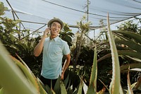 Cheerful man talking on the phone in a botanical garden