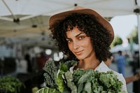 Beautiful woman buying kale at a farmers market