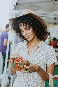 Beautiful woman buying tomatoes at a farmers market