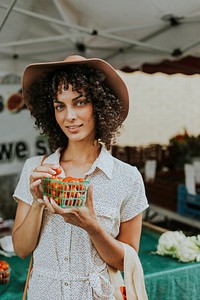 Beautiful woman buying tomatoes at a farmers market