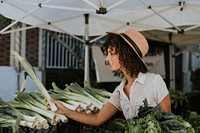 Beautiful woman buying vegetables at a farmers market