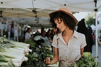 Beautiful woman buying kale at a farmers market