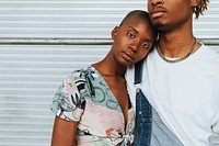 African american couple posing by a wall