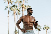 Fit man listening to music while at the beach