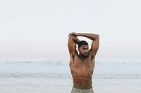 Fit man stretching at the beach