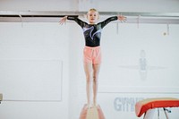 Young gymnast balancing on a balance beam