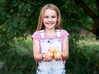 Young girl holding apples in her hands