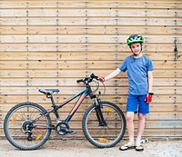 Young boy standing with his bike