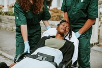 Paramedics moving a patient on a stretcher to an ambulance