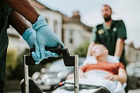 Paramedics moving a patient on a stretcher to an ambulance