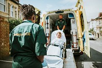 Paramedics moving a young patient on a stretcher into an ambulance
