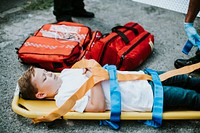 Young injured boy lying on an ambulance stretcher
