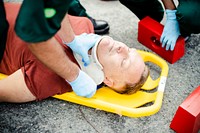 Paramedic team  placing a cervical collar to an injured man