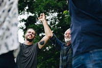 Happy diverse people holding hands in the park