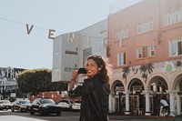 Cheerful woman taking a photo of Venice Beach