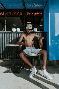 Shirtless man sitting at a cafe