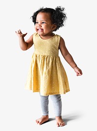 Happy little girl in a yellow dress