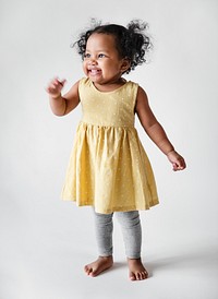 Happy little girl in a yellow dress