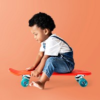 Cute little boy sitting on a skateboard