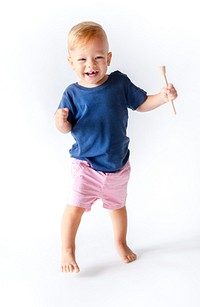 Cheerful toddler with a wooden stick toy