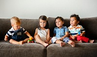 Diverse young kids sitting on the couch together
