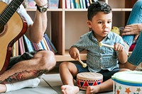 Little boy playing with a wooden drum set