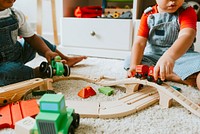 Little children playing with a railroad train toy