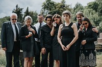 Sad family standing at a cemetery