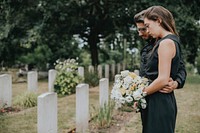 Couple standing together by a gravestone