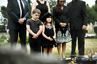 Sad grandkids standing by the grave