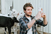 Happy man taking a selfie with baby goats