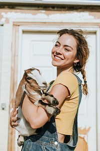 Portrait of a beautiful young woman with a goat