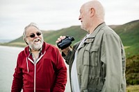Senior men standing together with a pair of binoculars