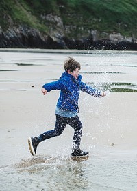 Cheerful boy running on the beach