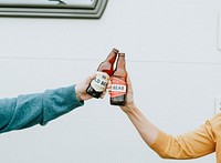 Hands clinking bottle of beers