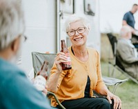 Happy senior woman with a bottle of beer