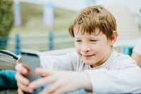 Happy boy playing on a mobile phone
