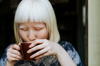 Sweet albino woman having a cup of coffee