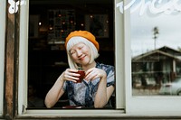 Albino girl with an orange beret sitting at a cafe