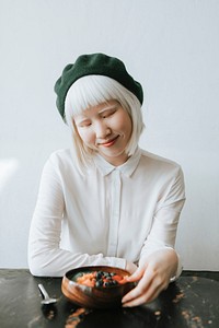 Albino girl with a green beret sitting at a cafe