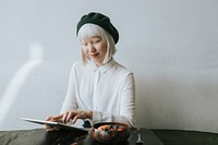 Albino girl with a green beret sitting at a cafe